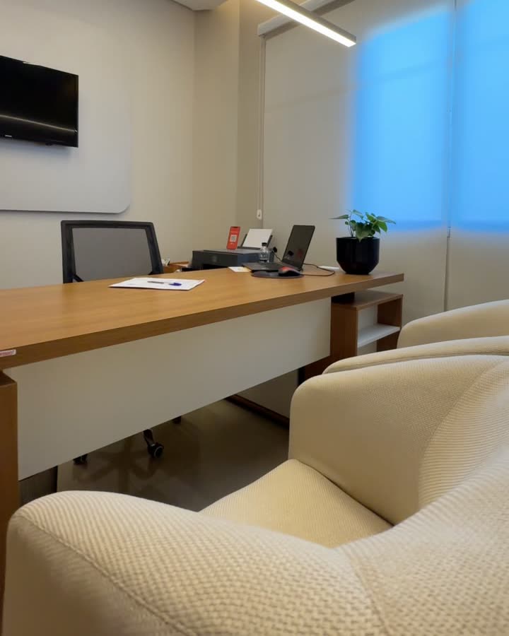 Consultório com mesa e poltronas