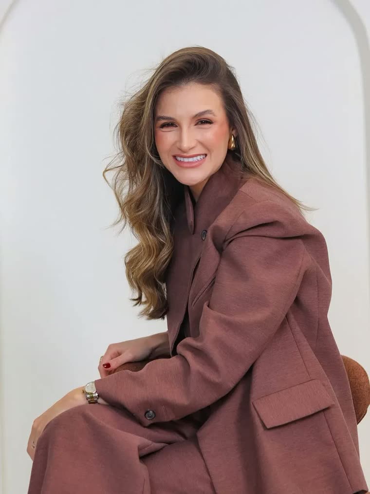 Dra. Mariana Vilela, sorrindo, de blazer marrom